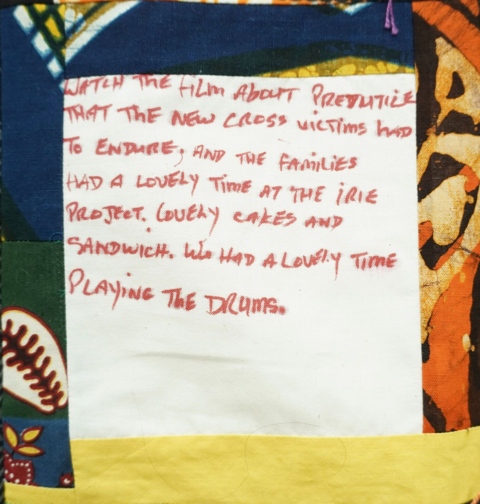 Commemorative quilt. Text reads, 'Watch the film about prejudice that the New Cross victims had to endure. And the families. Had a lovely time at the IRIE project, lovely cakes and sandwiches. We had a lovely time playing the drums'