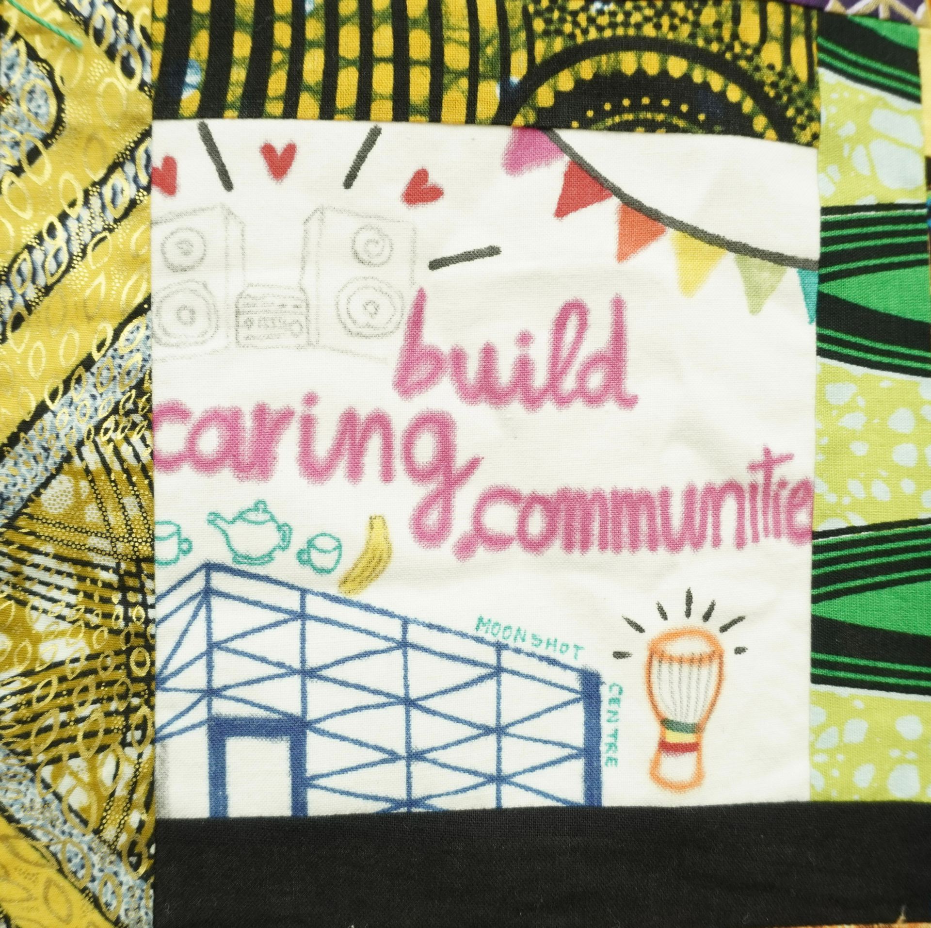 Commemorative quilt. Text reads, 'Build caring communities'