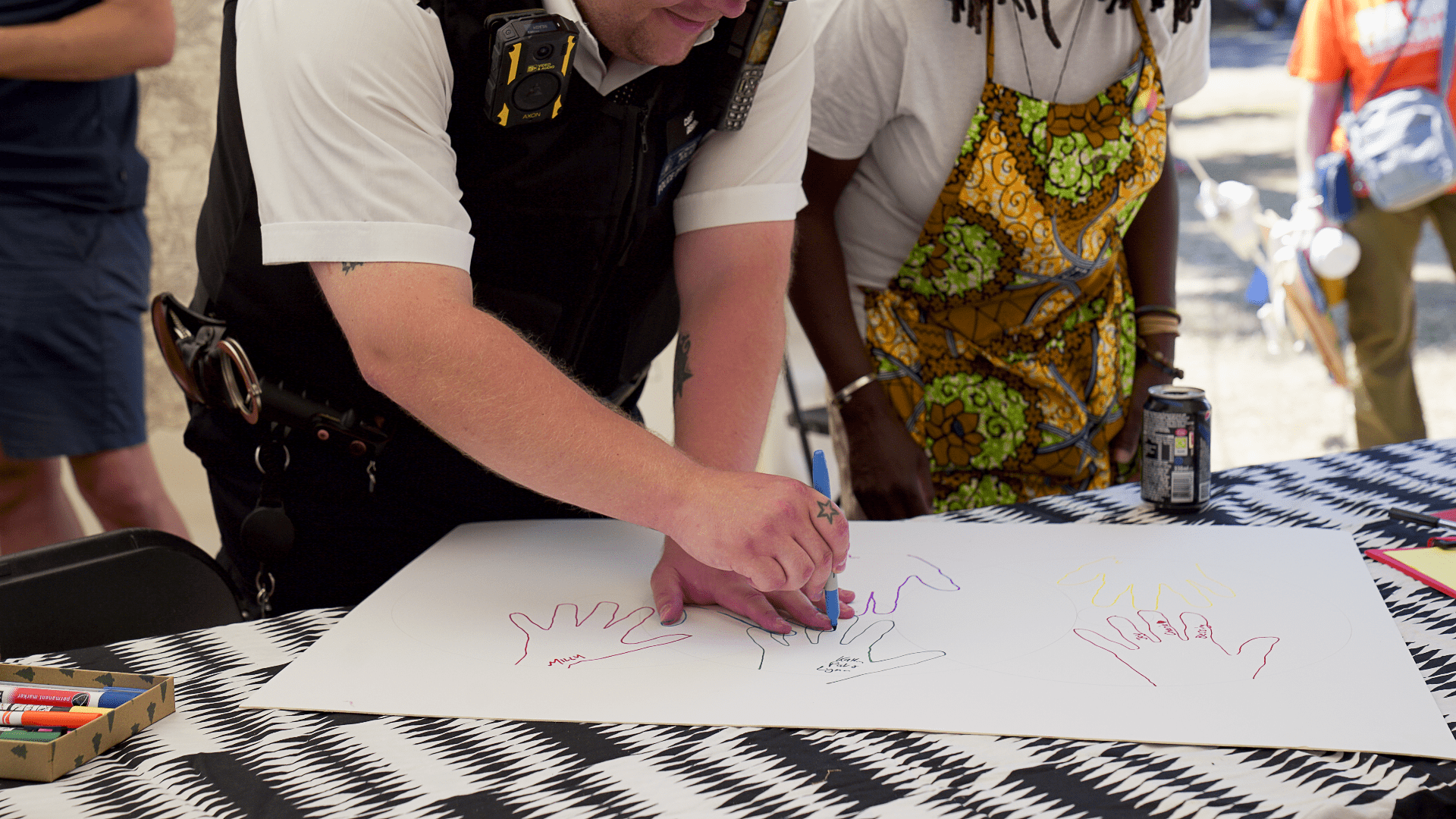 Policeman tracing his own hand on a piece of paper