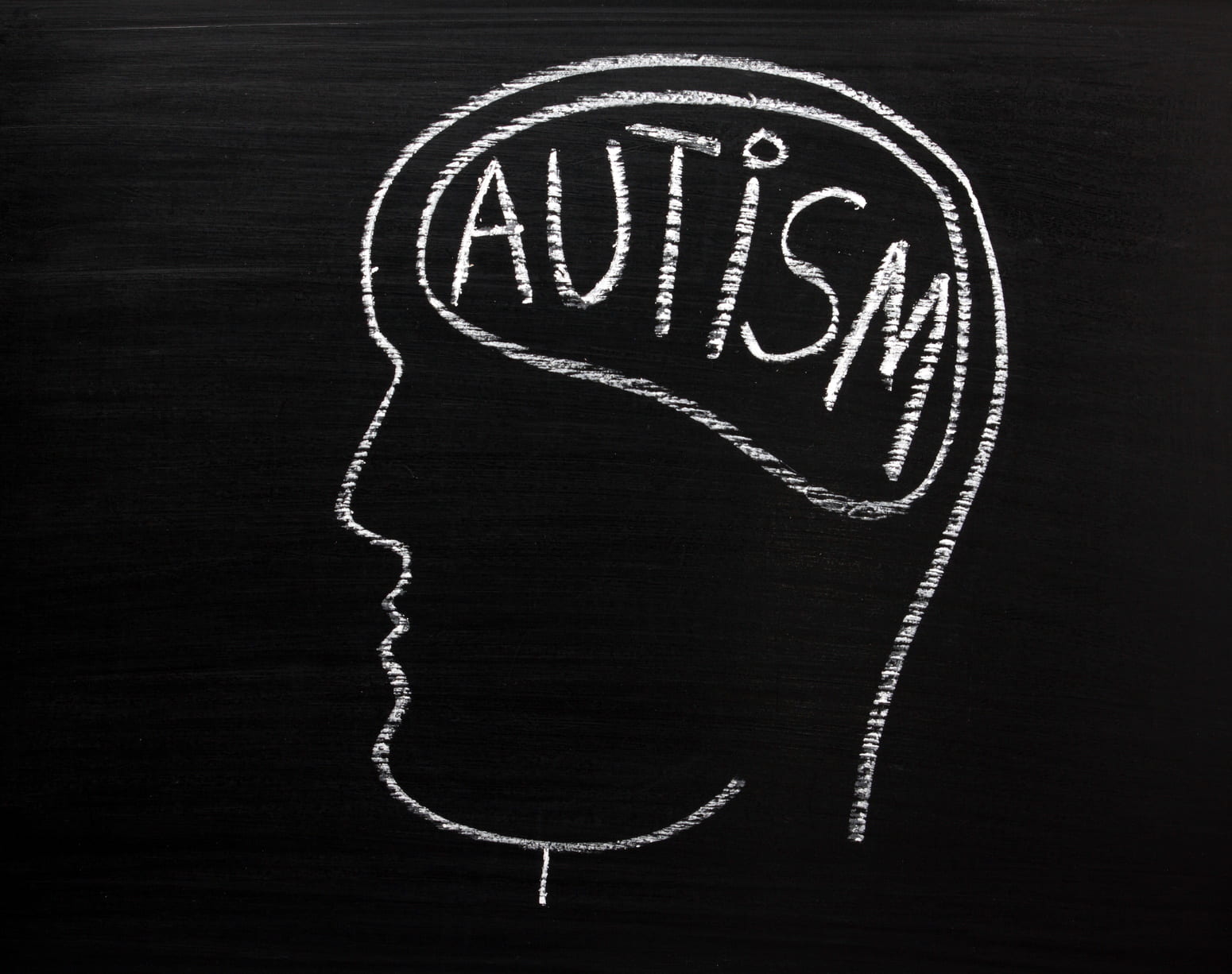 Human head on a blackboard with the word Autism on the brain
