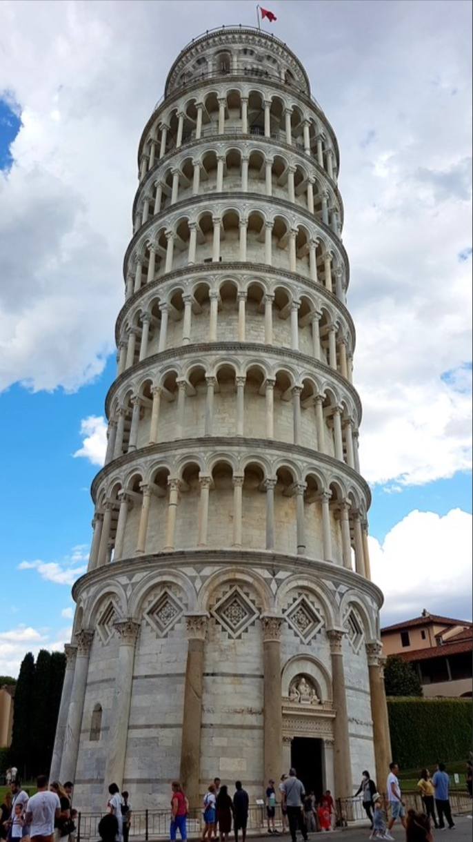 Close up of the leaning tower of Pisa with bright blue sky and white clouds in the background.