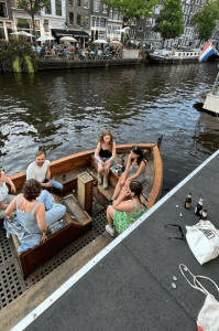 a group of people sat in a small boat on a body of water