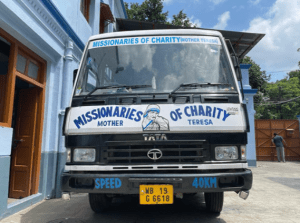 picture of the front of a small truck-style vehicle with 'missionaries of charity' and a picture of Mother Teresa painted on the front