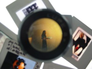 magnifier positioned over a 35mm slide showing image of artist